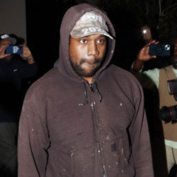 Kanye West is being slammed as sick for wearing a black version of a KKK-style hood